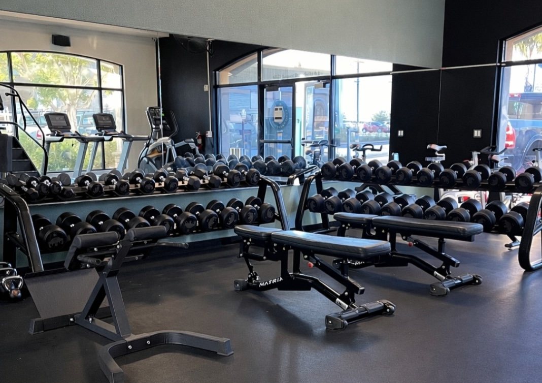Dumbbell racks, adjustable benches and cardio equipment on the Fox Fitness gym floor